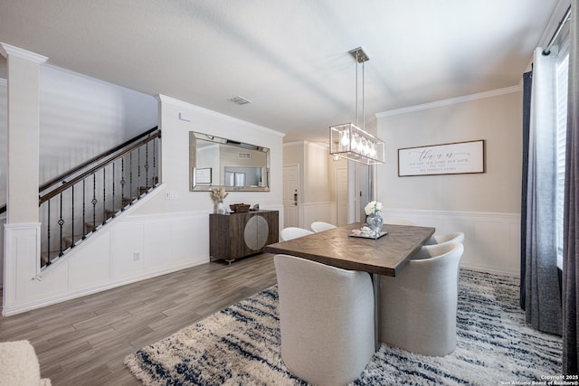 dining area with crown molding and light hardwood / wood-style floors