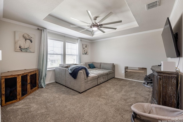 living room featuring crown molding, ceiling fan, a tray ceiling, and light carpet