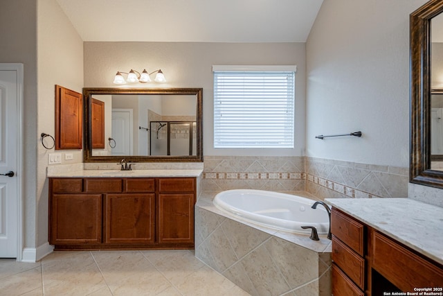 bathroom featuring vaulted ceiling, vanity, plus walk in shower, and tile patterned flooring