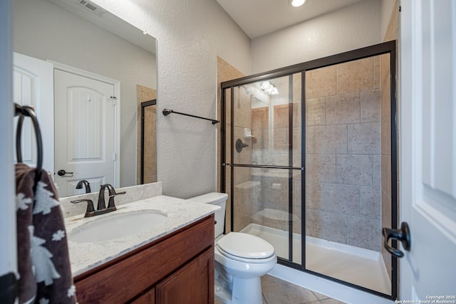 bathroom featuring vanity, tile patterned floors, toilet, and walk in shower