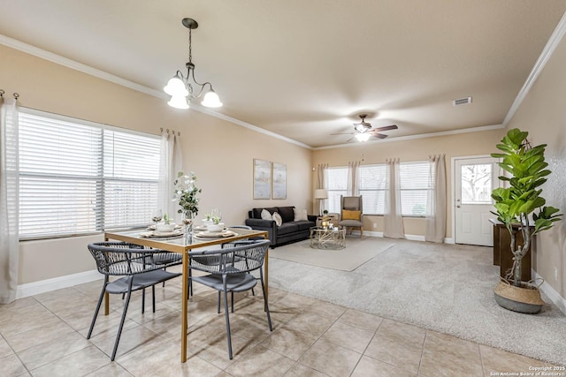 carpeted dining space featuring crown molding, plenty of natural light, and ceiling fan with notable chandelier