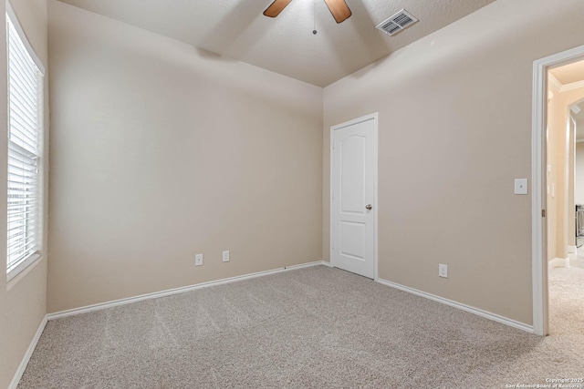 carpeted empty room featuring ceiling fan