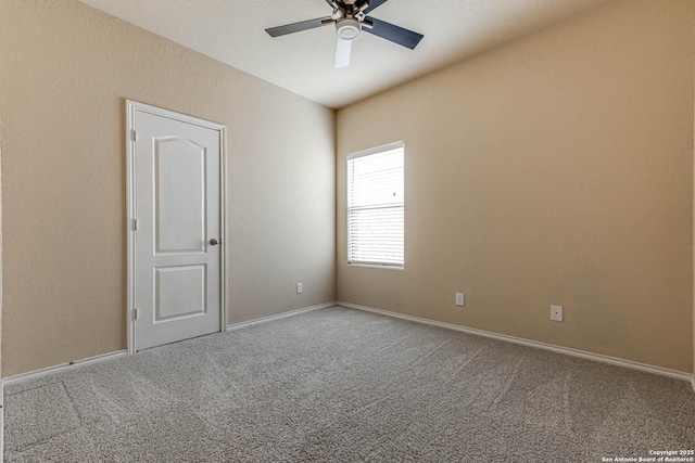 spare room with ceiling fan and carpet