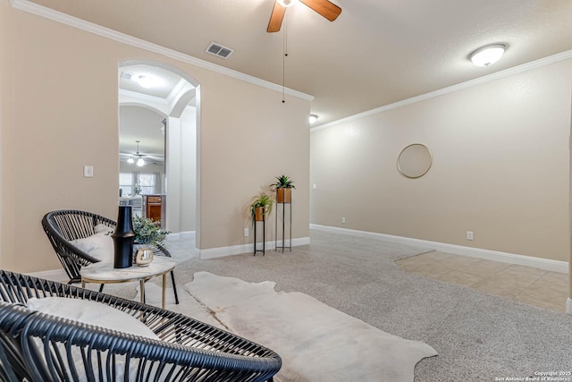 sitting room featuring ceiling fan, ornamental molding, and light carpet