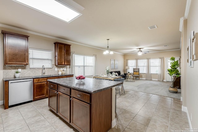 kitchen featuring crown molding, stainless steel dishwasher, sink, and a kitchen island