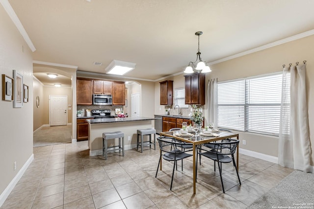 dining room featuring an inviting chandelier, light tile patterned floors, crown molding, and sink