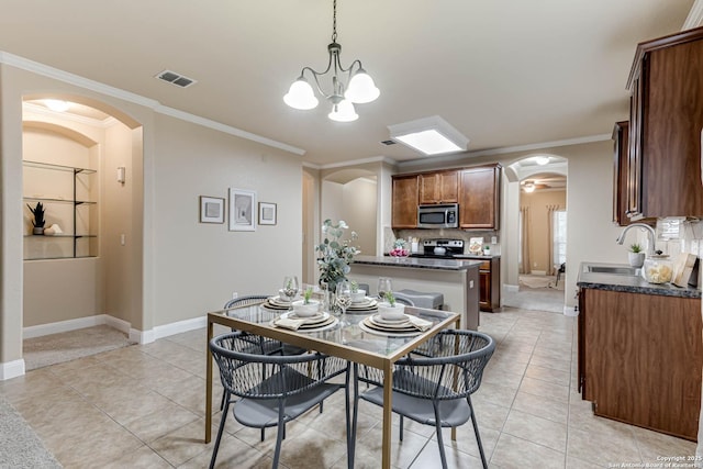 dining area with light tile patterned flooring, ornamental molding, sink, and a chandelier