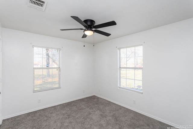 empty room featuring carpet floors, a wealth of natural light, and ceiling fan