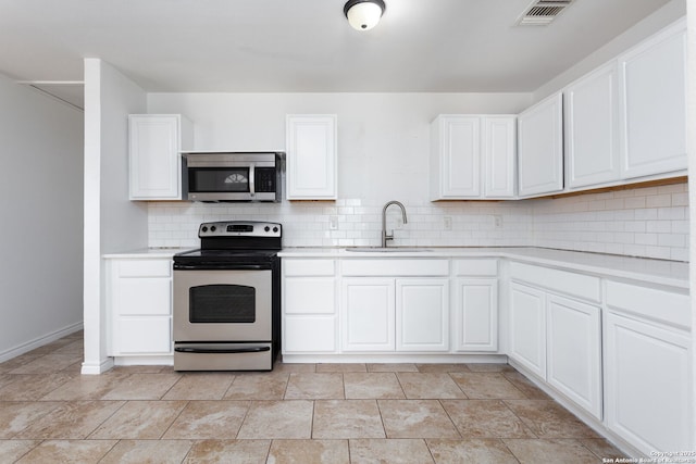 kitchen featuring white cabinetry, stainless steel appliances, sink, and backsplash