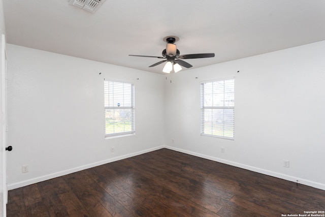 unfurnished room featuring dark wood-type flooring, a wealth of natural light, and ceiling fan