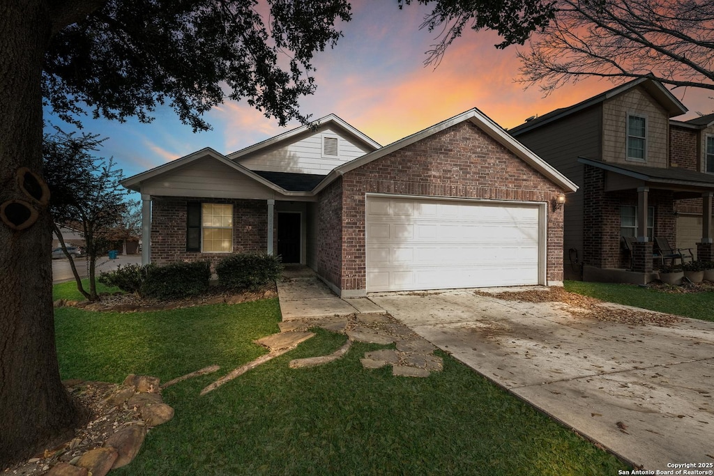 view of front of property with a garage and a lawn