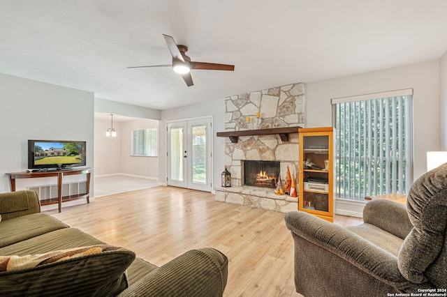 living room featuring wood-type flooring, a fireplace, a healthy amount of sunlight, and ceiling fan