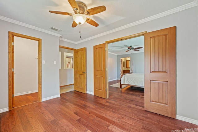 unfurnished bedroom featuring hardwood / wood-style flooring, ornamental molding, and ceiling fan