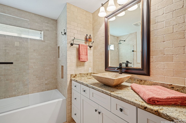 bathroom featuring vanity and tiled shower / bath