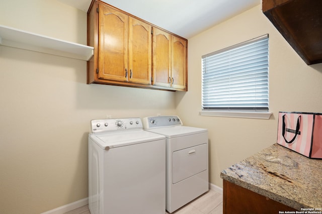 laundry room featuring cabinets and washing machine and clothes dryer