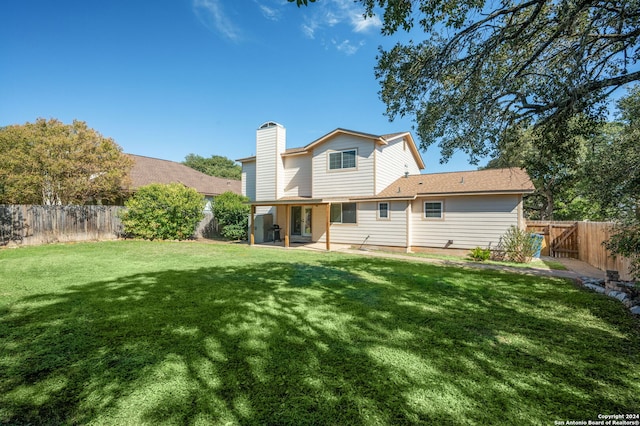 rear view of house featuring a patio and a lawn