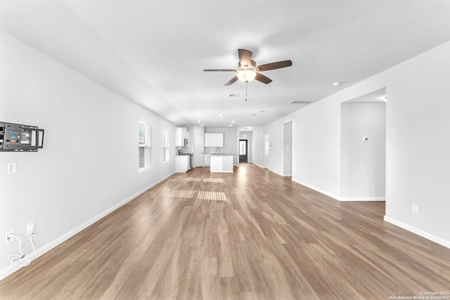 unfurnished living room featuring hardwood / wood-style flooring and ceiling fan