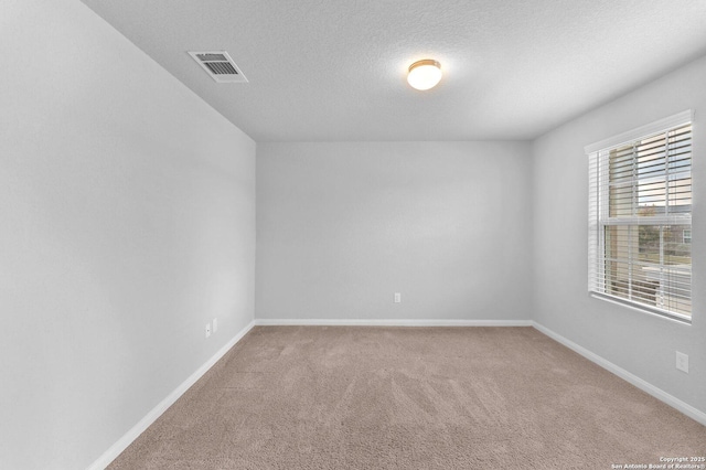 carpeted spare room with a textured ceiling