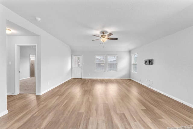 unfurnished living room with ceiling fan, a textured ceiling, and light wood-type flooring