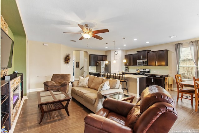 living room with ceiling fan and light hardwood / wood-style flooring