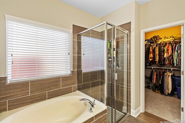 bathroom featuring shower with separate bathtub