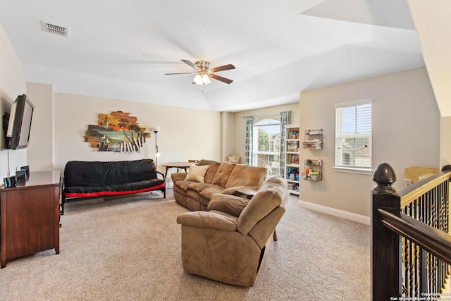 living room featuring light carpet, a raised ceiling, and ceiling fan