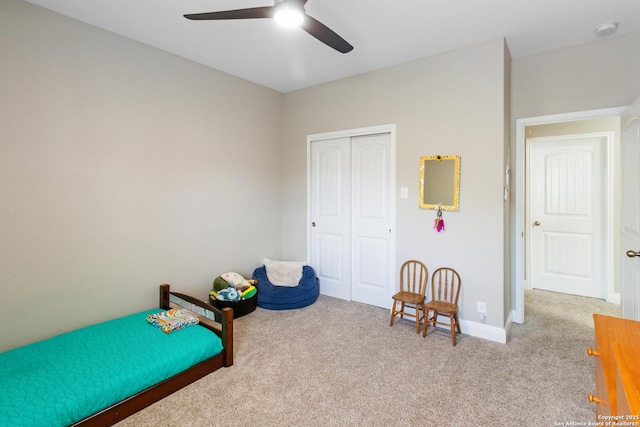 bedroom with light colored carpet, ceiling fan, and a closet