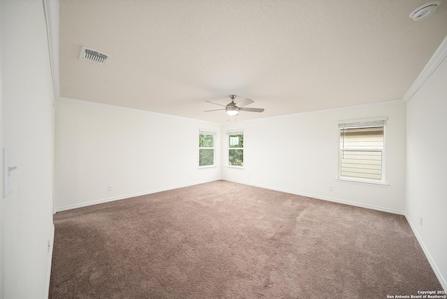 empty room featuring crown molding, ceiling fan, and dark carpet