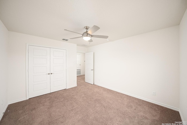 unfurnished bedroom featuring ceiling fan, a closet, and carpet