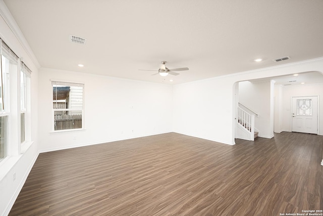 unfurnished living room featuring dark wood-type flooring, ceiling fan, and ornamental molding