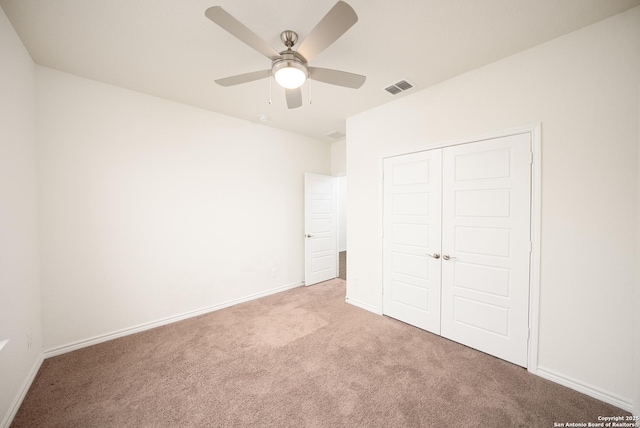 unfurnished bedroom featuring light colored carpet, ceiling fan, and a closet