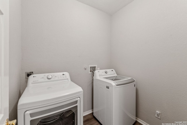 washroom featuring dark hardwood / wood-style floors and washing machine and clothes dryer