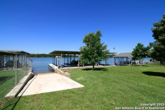 dock area with a water view and a lawn