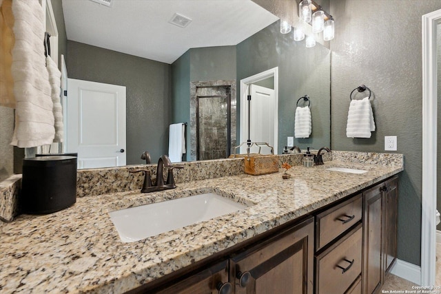 bathroom with a shower with door and vanity