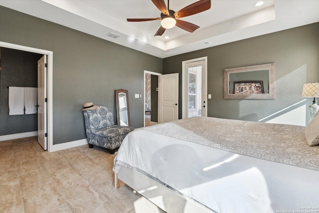 bedroom with ceiling fan and a tray ceiling