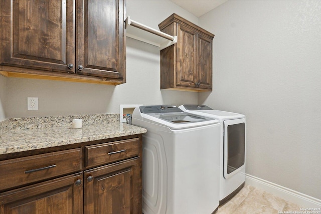 laundry area featuring cabinets, light tile patterned flooring, and washing machine and clothes dryer