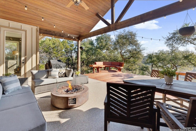 view of patio / terrace with ceiling fan, a deck, and an outdoor living space with a fire pit