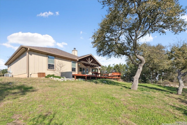 back of property featuring a yard and a deck