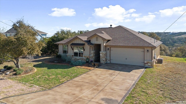 view of front of property with a garage, a front yard, and cooling unit