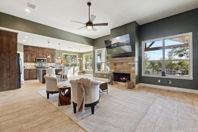 living room featuring a fireplace and ceiling fan