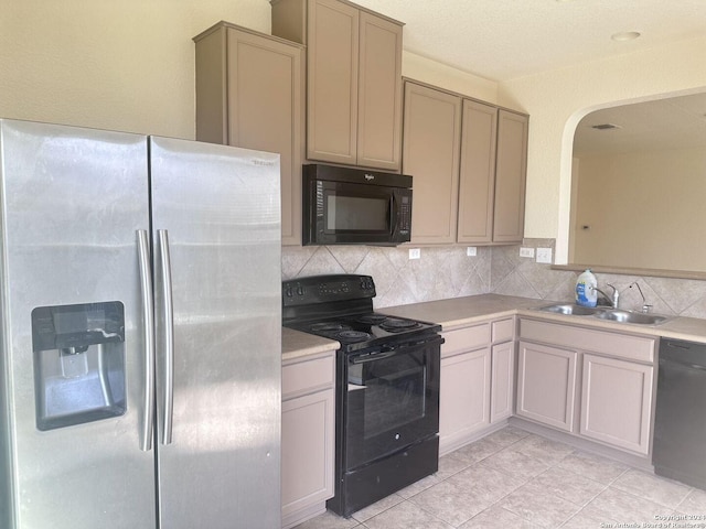 kitchen with light tile patterned floors, sink, decorative backsplash, and black appliances