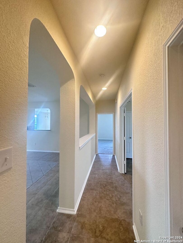 hallway with dark tile patterned floors