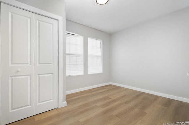 unfurnished bedroom featuring a closet and light hardwood / wood-style flooring