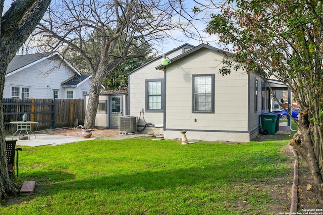 rear view of property featuring central air condition unit, a patio area, and a lawn