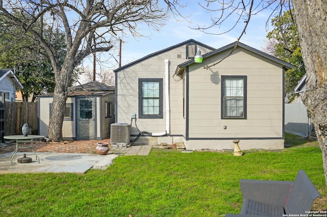 rear view of property with a yard, central AC unit, and a patio