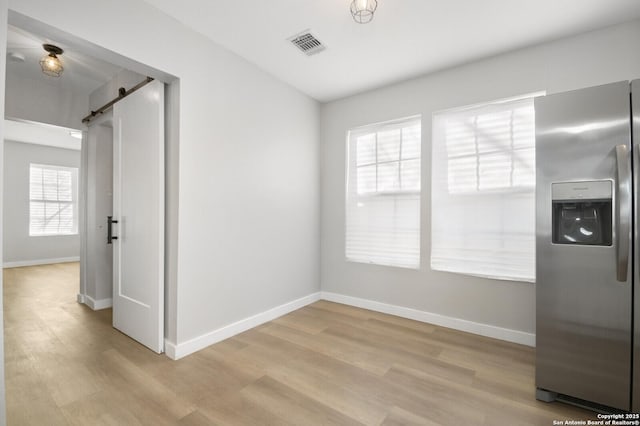 interior space featuring a barn door and light hardwood / wood-style flooring