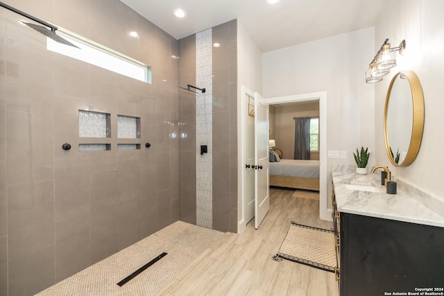 bathroom with vanity, hardwood / wood-style flooring, and tiled shower