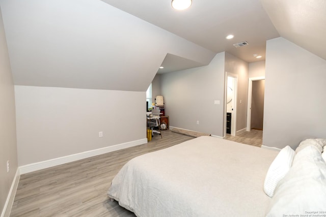 bedroom with vaulted ceiling and light hardwood / wood-style floors