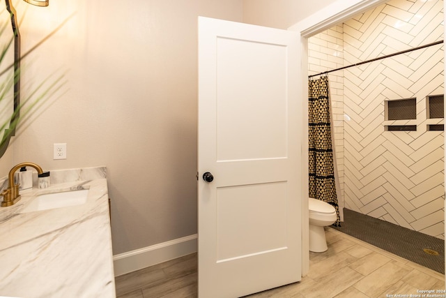 bathroom featuring wood-type flooring, toilet, vanity, and a shower with shower curtain