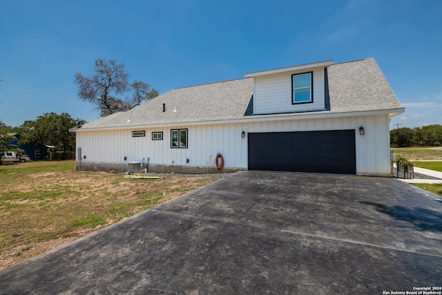 modern farmhouse style home with a garage, central AC, and a front yard